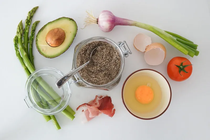 Bodegón con aguacate, huevo, espárragos y tomate, alimentos ricos en potasio y grasa buena para la dieta keto